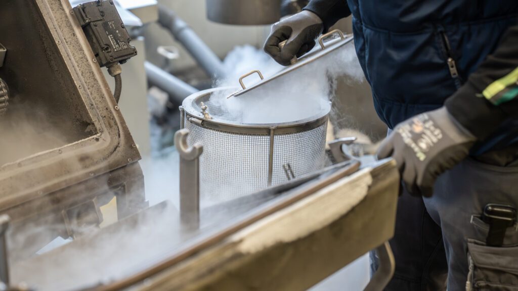 Industrielle Maschine zum Strahlentgraten wird geöffnet und dampft