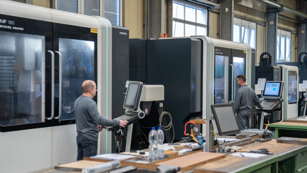 Zwei Mitarbeiter im Formenbau vor CNC Maschinen